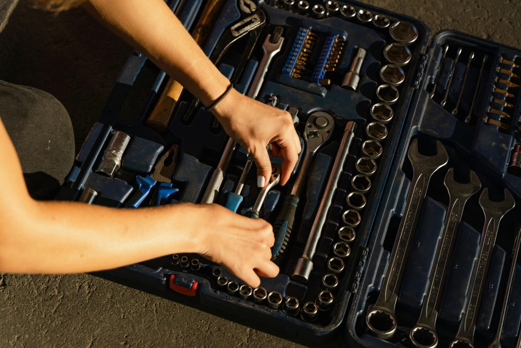 A woman's hands picking a tool from a toolbox